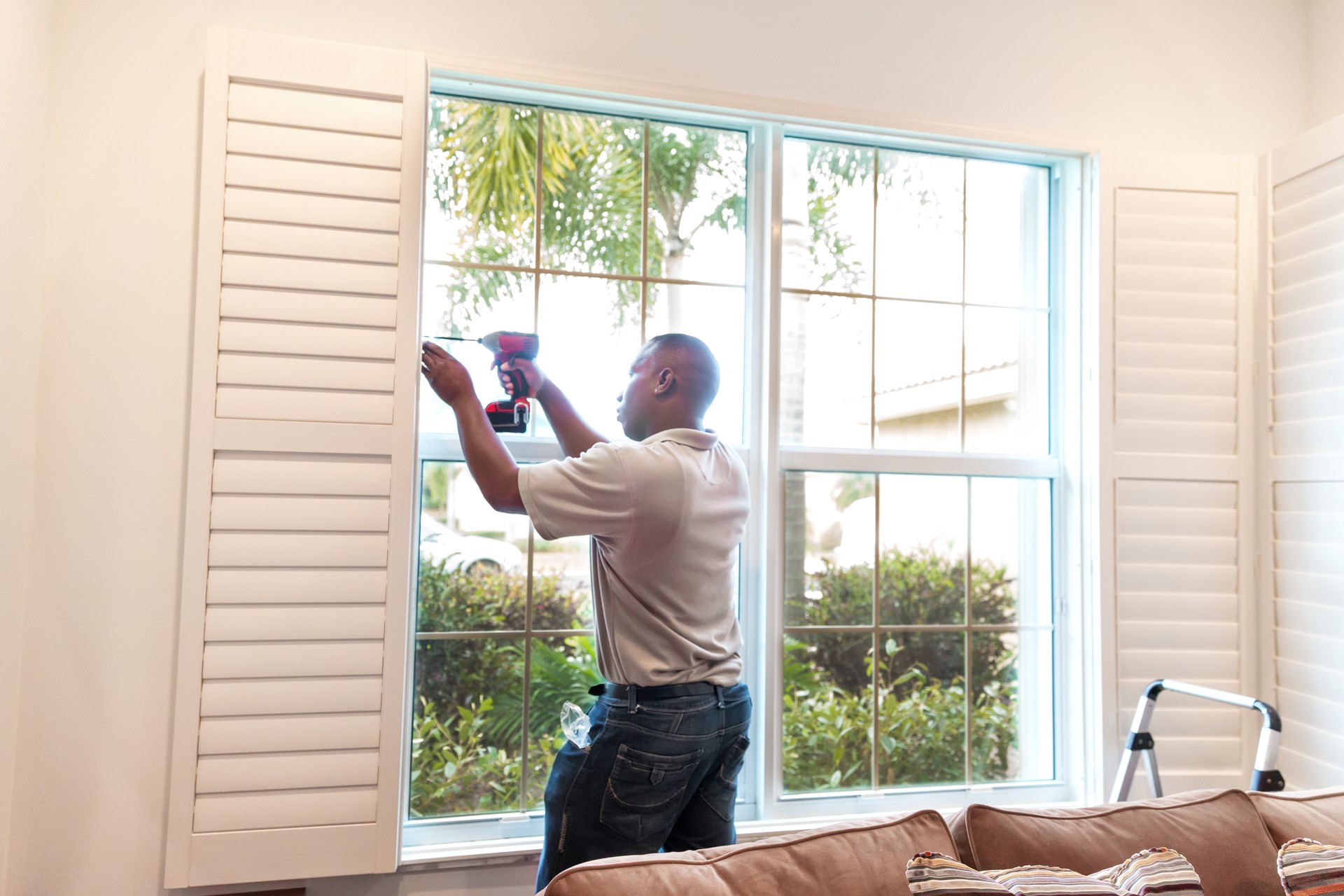 Window treatment installer installs wooden shutters  RM