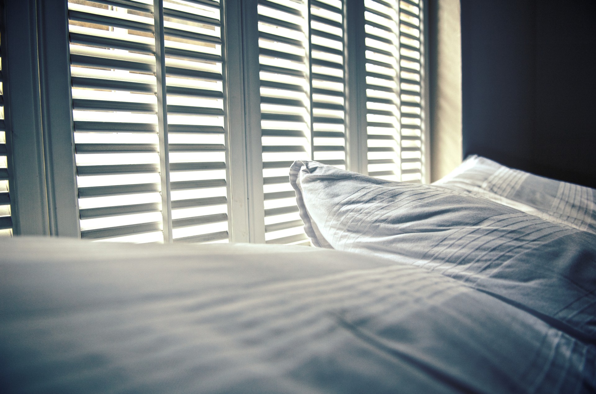 White linen against white shutters with white light behind